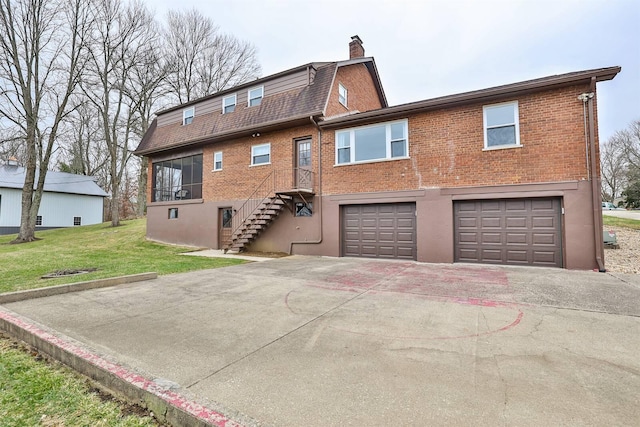 back of property with a garage and a yard