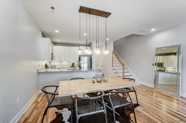 dining area featuring sink and light wood-type flooring