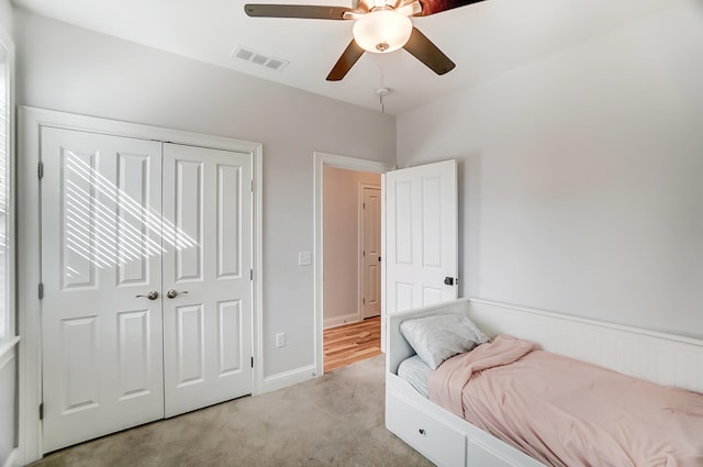 carpeted bedroom featuring ceiling fan and a closet