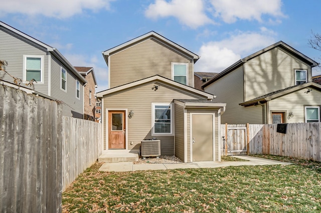 rear view of property featuring a yard and central air condition unit