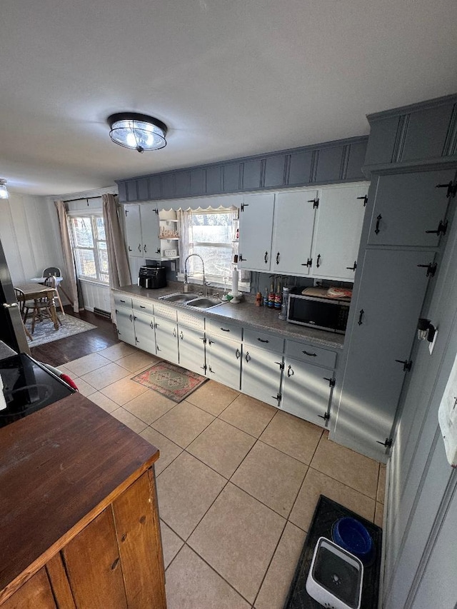 kitchen featuring white cabinetry, light tile patterned floors, and sink