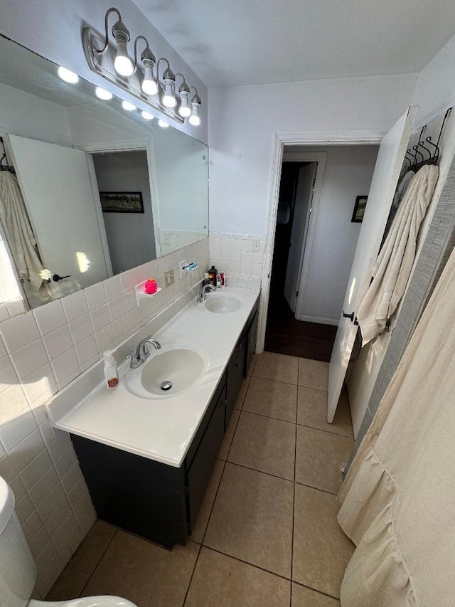 bathroom with tile patterned flooring, vanity, tile walls, and toilet