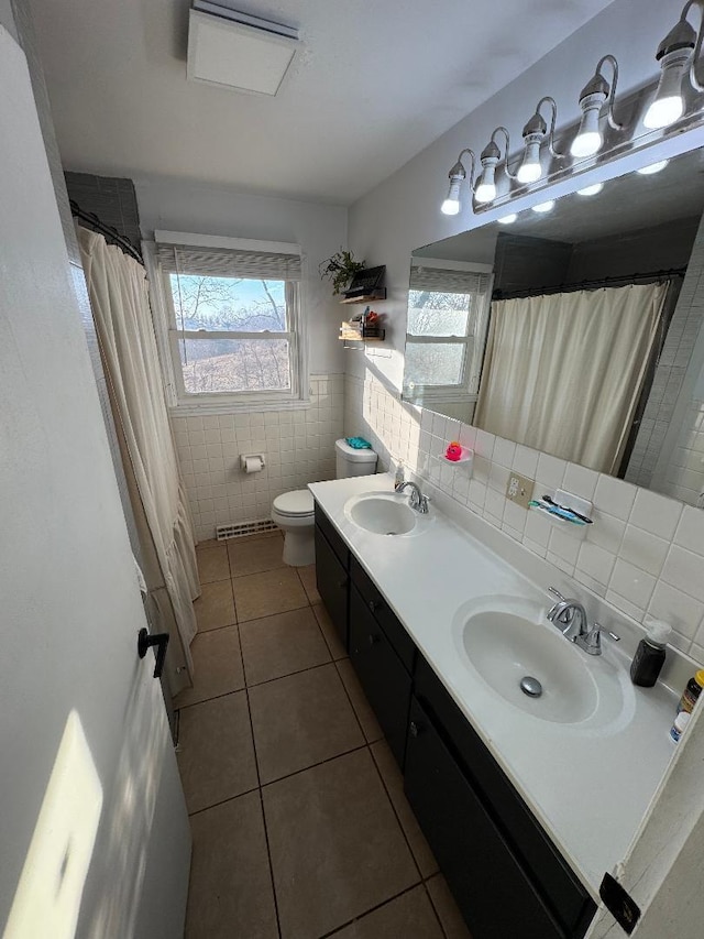 bathroom with vanity, tile patterned floors, toilet, and tile walls