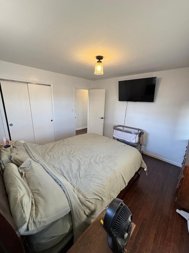 bedroom with dark hardwood / wood-style flooring and a closet