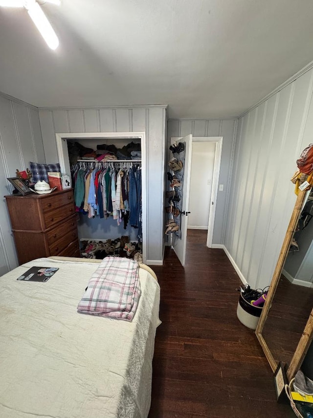 bedroom with dark hardwood / wood-style flooring and a closet