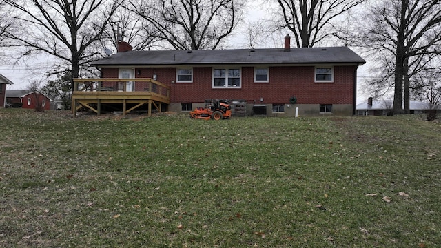 rear view of house featuring a yard and a deck