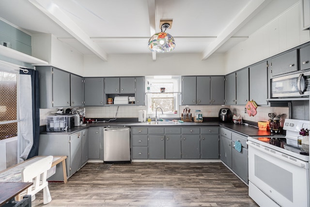 kitchen featuring gray cabinetry, stainless steel appliances, and beamed ceiling