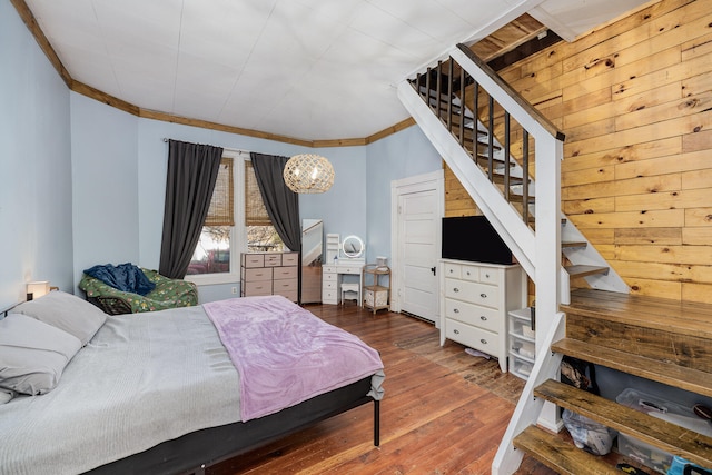 bedroom with an inviting chandelier, dark wood-type flooring, and ornamental molding