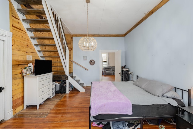 bedroom featuring crown molding, hardwood / wood-style floors, and a notable chandelier