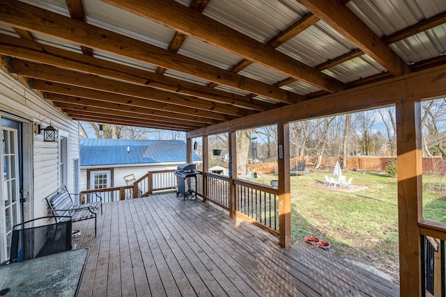 wooden terrace with a grill, a fire pit, and a lawn