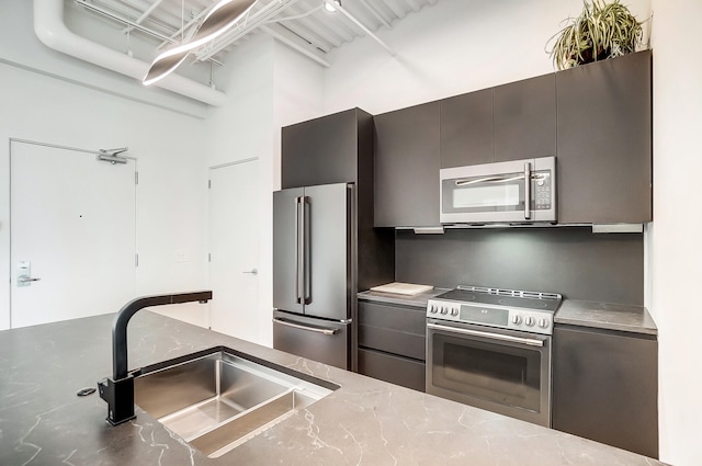 kitchen with stainless steel appliances, a sink, and modern cabinets