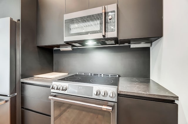 kitchen with stainless steel appliances, stainless steel counters, and modern cabinets