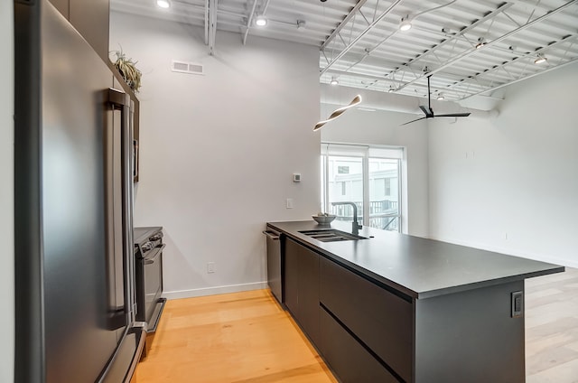 kitchen featuring light wood finished floors, visible vents, appliances with stainless steel finishes, modern cabinets, and a peninsula