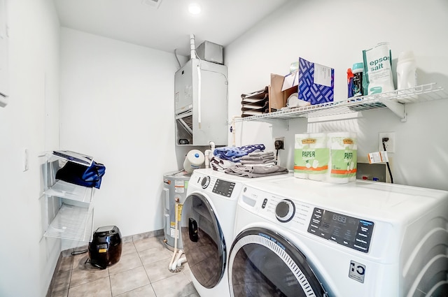 clothes washing area with laundry area, light tile patterned flooring, and washing machine and clothes dryer