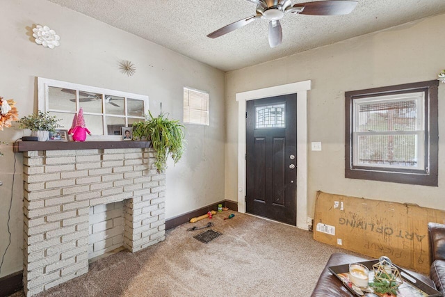 carpeted entrance foyer featuring ceiling fan, a brick fireplace, and a textured ceiling