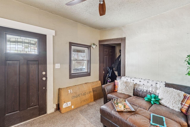 carpeted living room featuring ceiling fan, plenty of natural light, and a textured ceiling