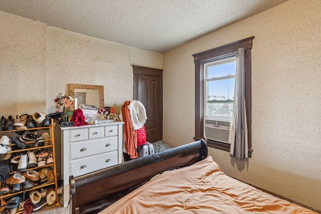 bedroom featuring cooling unit and a textured ceiling