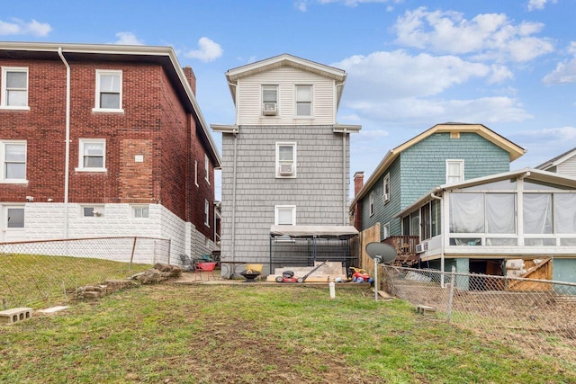 back of property with a yard and a sunroom