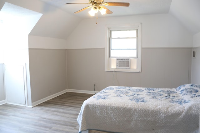 bedroom featuring cooling unit, lofted ceiling, wood-type flooring, and ceiling fan