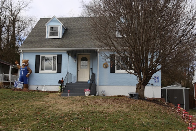 cape cod-style house with a shed and a front lawn