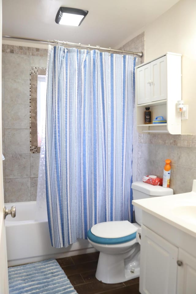 full bathroom featuring vanity, tile walls, shower / tub combo, and toilet