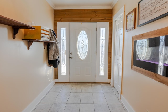 tiled foyer featuring ornamental molding and wood walls