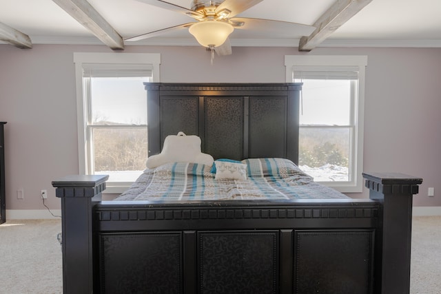 carpeted bedroom with multiple windows, ceiling fan, and beamed ceiling