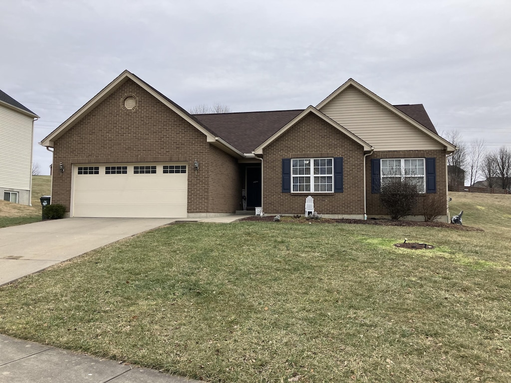 ranch-style house featuring a garage and a front lawn