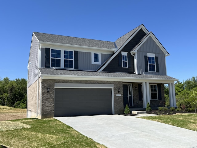 1703 Barons Cv, Hebron, KY 41048 - view of front facade featuring driveway, covered porch, board and batten siding, and a front yard