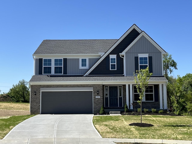 1703 Barons Cv, Hebron, KY 41048 - view of front of property with concrete driveway, a front lawn, board and batten siding, an attached garage, and a shingled roof
