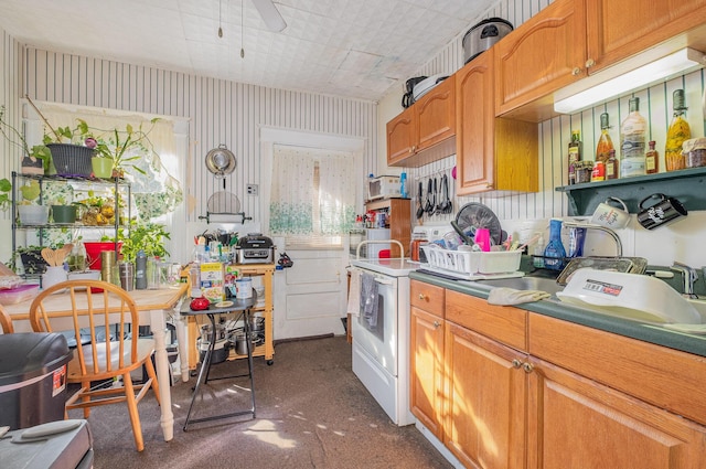 kitchen featuring a ceiling fan, brown cabinetry, and electric stove