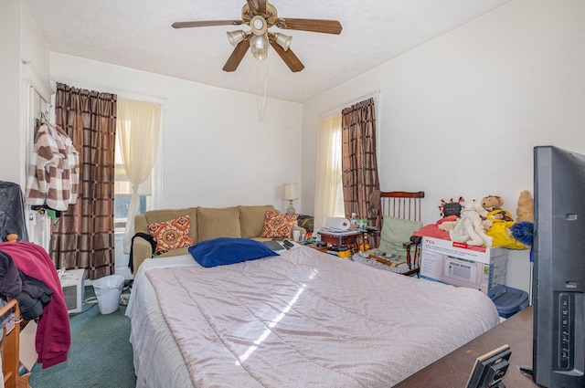 carpeted bedroom with ceiling fan and a textured ceiling