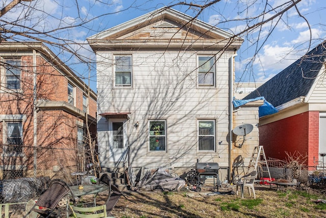 rear view of house featuring fence