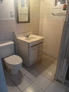 bathroom featuring tile patterned flooring, vanity, and toilet