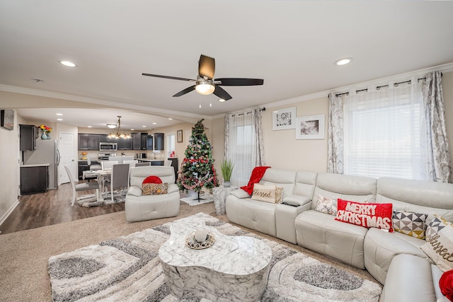 living room featuring ornamental molding, ceiling fan with notable chandelier, and dark hardwood / wood-style flooring