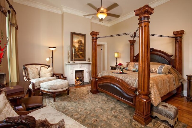 bedroom featuring crown molding, wood-type flooring, and ornate columns