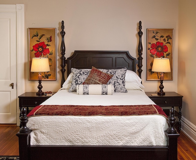 bedroom with dark hardwood / wood-style flooring