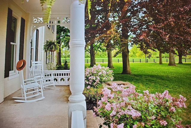 view of yard with covered porch and a rural view