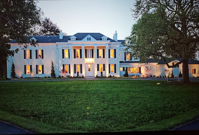 neoclassical home with a lawn