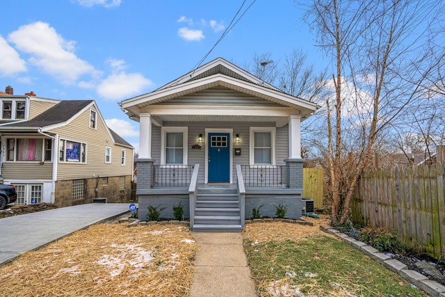 bungalow-style home featuring a porch and cooling unit