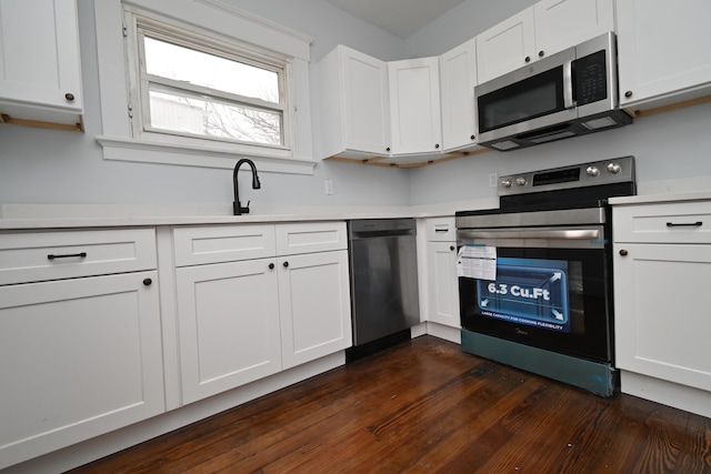 kitchen featuring white cabinets, appliances with stainless steel finishes, sink, and dark hardwood / wood-style flooring