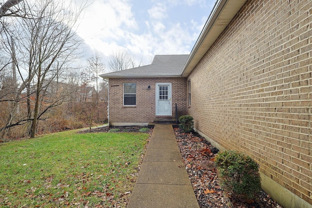 view of exterior entry featuring a lawn