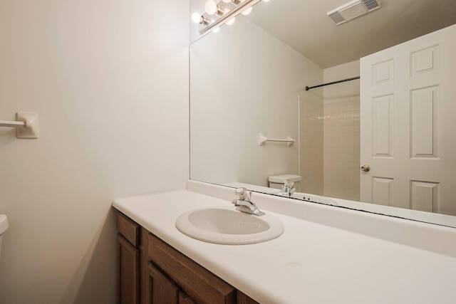 bathroom featuring vanity, toilet, and a shower