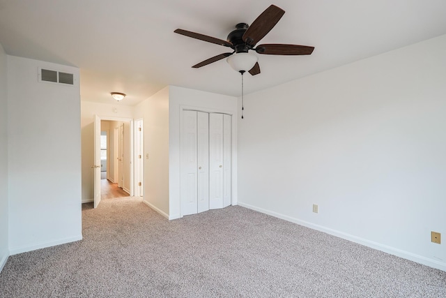 unfurnished bedroom featuring ceiling fan, a closet, and light carpet