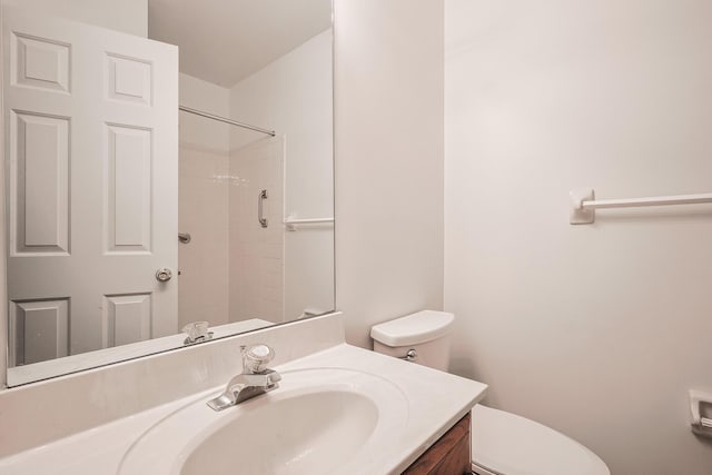 bathroom featuring vanity, toilet, and walk in shower