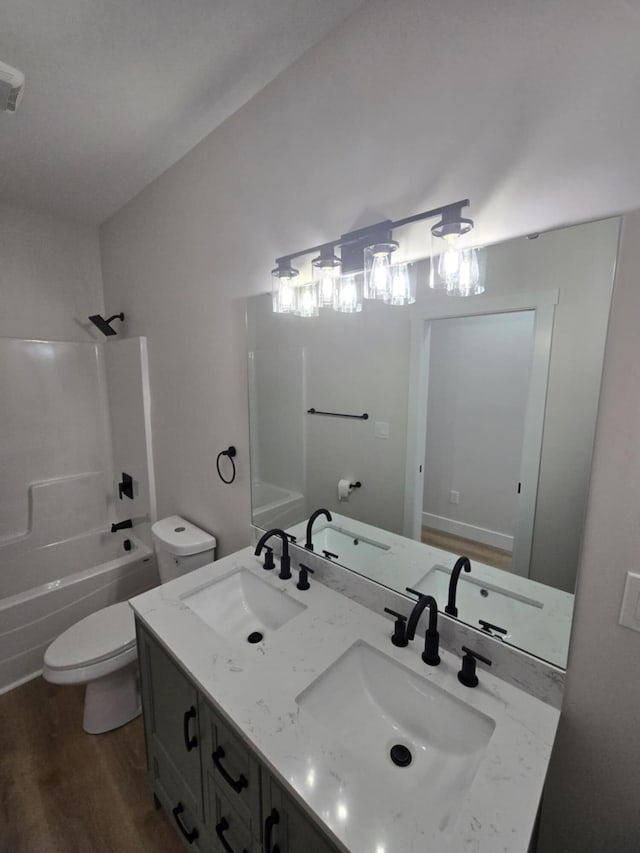 full bathroom featuring lofted ceiling, hardwood / wood-style flooring, shower / bath combination, vanity, and toilet