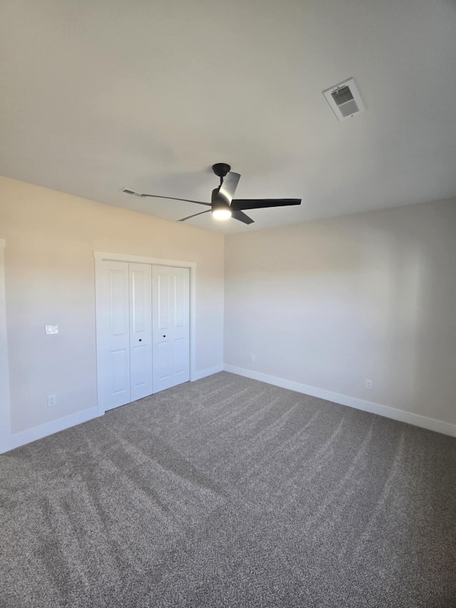 unfurnished bedroom featuring carpet floors, a closet, and ceiling fan