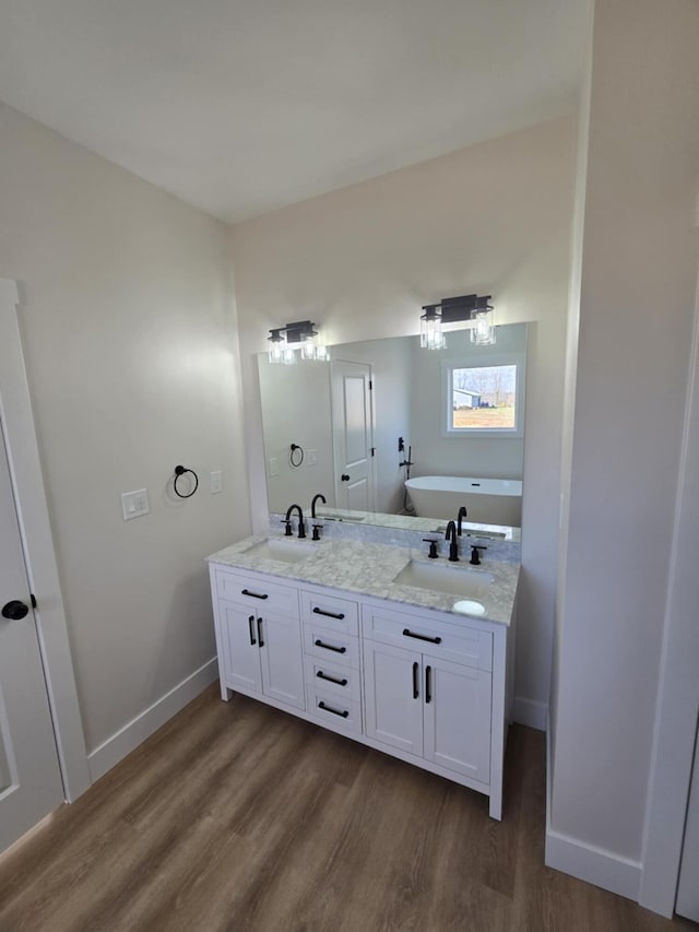 bathroom featuring vanity, a bath, and hardwood / wood-style flooring