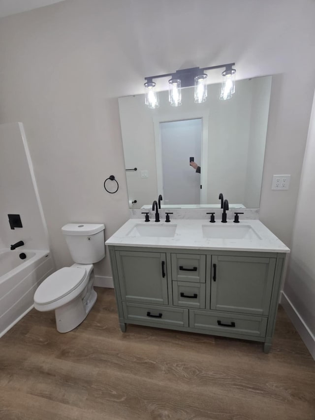 full bathroom featuring vanity, hardwood / wood-style flooring, tub / shower combination, and toilet