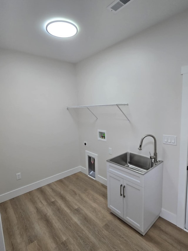 laundry area with sink, cabinets, light wood-type flooring, washer hookup, and hookup for an electric dryer